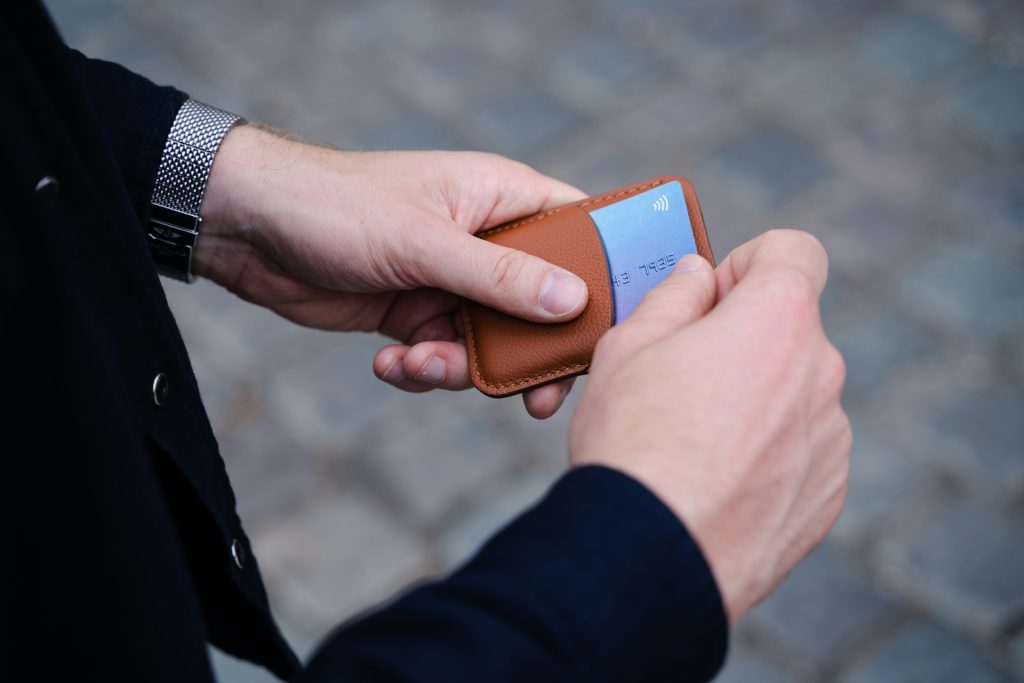 A man holding a prepaid credit card and about to make a transaction with it